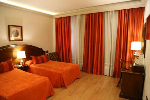 格拉纳达安娜公主酒店的酒店客房,设有两张床和红色窗帘