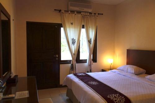 塞米亚克尼拉玛雅别墅酒店的一间卧室设有一张大床和一个窗户。