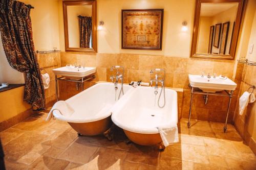 阿伦德尔拜里弗斯考特酒店及水疗中心的浴室配有2个盥洗盆、浴缸和2个盥洗盆。