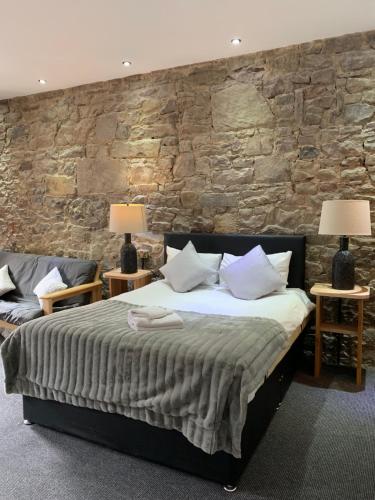 爱丁堡皇家大道城堡附近宾馆的一间卧室设有一张床和石墙