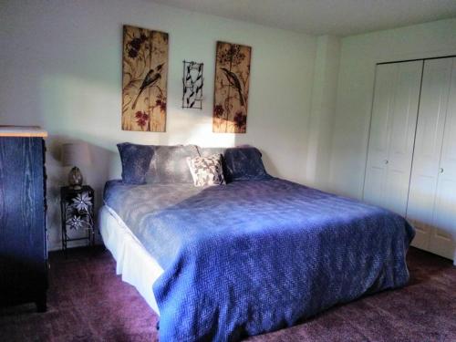 伍德兰Vancouver WA Beautiful Apartment的一间卧室配有一张带蓝色棉被的大床