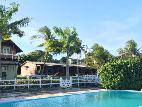 尼西亚弗洛雷斯塔Fazenda Bom Fim的棕榈树屋前的游泳池
