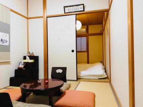 京都二条舎京小屋的带桌子的房间和配有床的房间