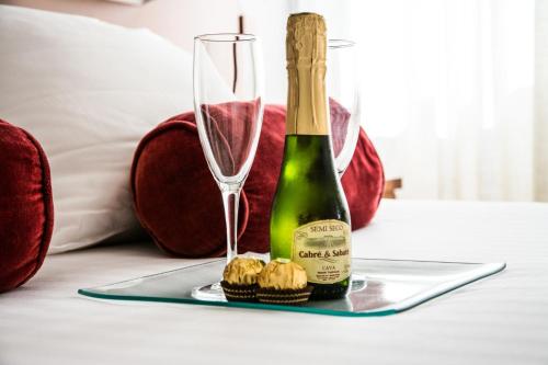 阿尔么丽亚科斯塔索尔酒店的一瓶香槟和一张桌子上的两杯酒