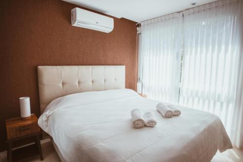 卡里罗Suite House Carilo的卧室配有白色的床和2条毛巾