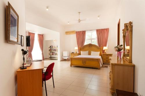 巴塔拉穆拉维拉53民宿的酒店客房配有一张床、一张书桌和一张书桌。