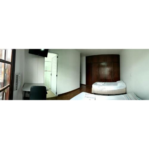 皮拉西卡巴Anexo São João的客房设有两张床、一张桌子和一个窗户。