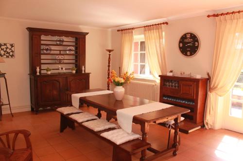 圣让-德吕兹Appartements de Chantaco的客厅配有木桌、长凳和时钟