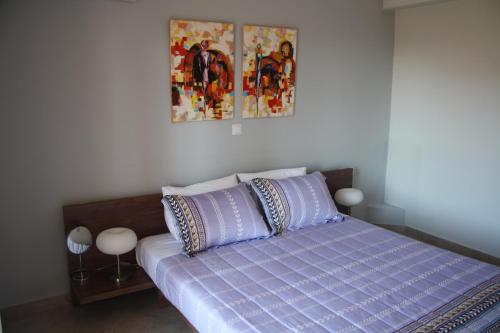 普希里阿莫斯Thalatta Seaside Accommodation的卧室内的一张带紫色床单和枕头的床