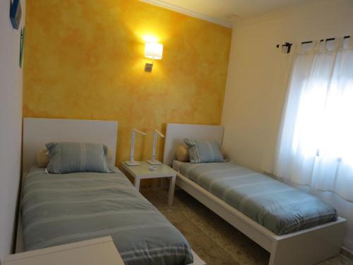 洛斯卡尼奥斯德梅卡La Casa del Trafalgar的两张床位于带窗户的房间内