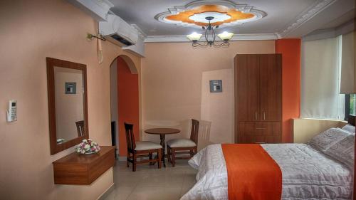 埃斯梅拉达斯Olan´s Hotel Group的卧室配有一张床和一张桌子及椅子