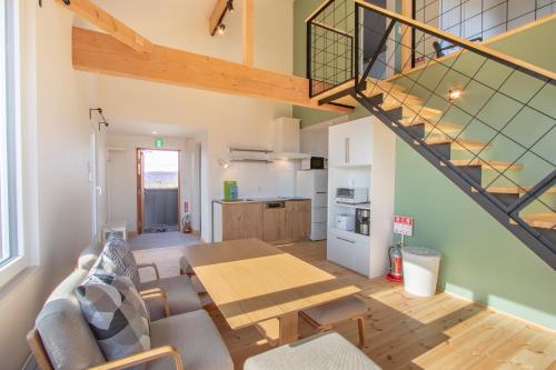 二世古Niseko Highland Cottages的一间带桌子和楼梯的客厅