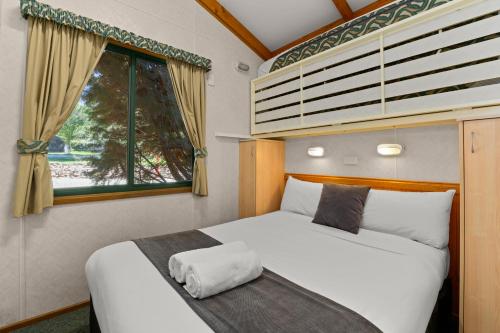 布赖特明亮滨江假日公园酒店的一间卧室设有两张床和窗户。