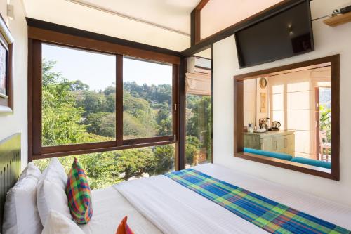 康提Hotel Yo Kandy的一间卧室设有一张床和一个大窗户