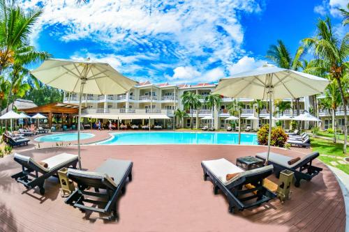 蒙舒瓦西Tarisa Resort & Spa的一个带游泳池、椅子和遮阳伞的度假村