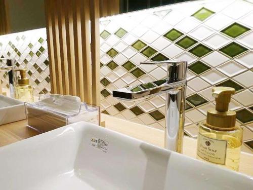 富士宫市富士宫亚多木屋的浴室水槽和柜台上的一瓶香水