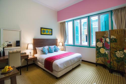 马六甲艾瓦马六甲酒店的酒店客房设有一张床、一张书桌和窗户。