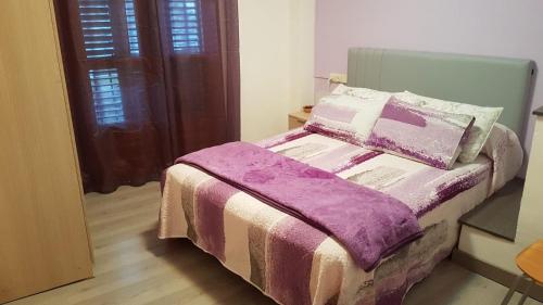 瓦伦西亚德奥尼Casa Ponet的一间卧室配有一张带紫色毯子的床
