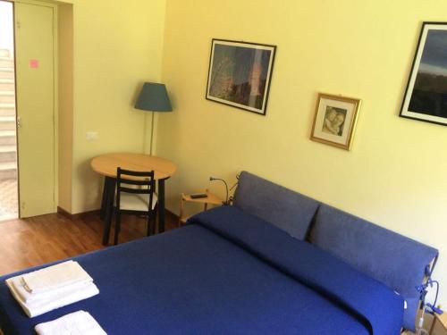 泰拉奇纳Queen bedroom的一间卧室配有一张蓝色的床和一张桌子