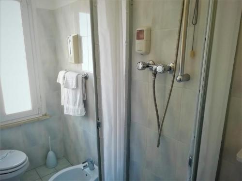 西尼加利亚Albergo Moretti的带淋浴、卫生间和盥洗盆的浴室