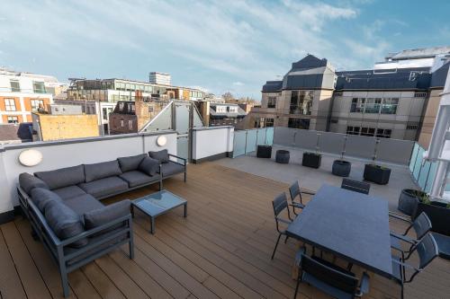 伦敦ALTIDO Luxury 2 bed flats with terraces near Piccadilly Circus的大楼内的阳台配有沙发和桌子