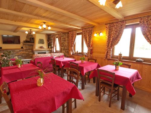 尚波吕克Villa Americana Chambres d'Hotes的餐厅设有红色的桌椅和窗户。
