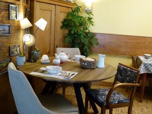 伊芙尔莱韦克Hôtel Motel Papea的木桌,上面放着碗和盘子
