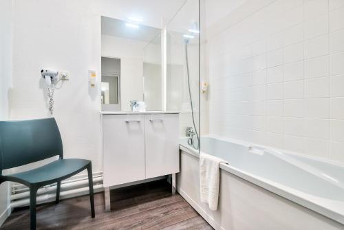 图卢兹图卢兹大都会泽尼图德公寓式酒店的一间带椅子、水槽和浴缸的浴室