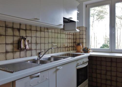 比斯平根Ferienwohnung Kiefernblick-Wedemann的白色的厨房设有水槽和窗户