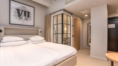 图尔库Original Sokos Hotel Wiklund的卧室配有白色的床和桌子