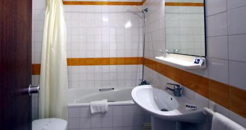波尔蒂芒鲁阿尔酒店的一间带水槽、浴缸和卫生间的浴室