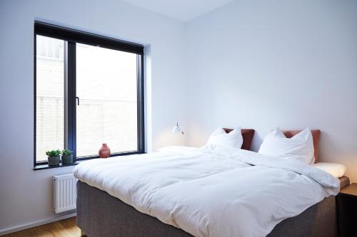 奥胡斯Amaliegade 10 B的窗户客房内的一张大白色床