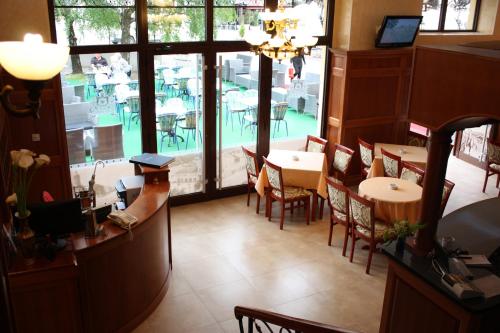 内戈廷贝尔格莱德加尼酒店的餐厅设有桌椅和大窗户。
