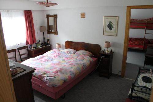 Martigny-CombeBig flat in the heart of Valais的一间卧室配有一张床、一张桌子和一个窗户。