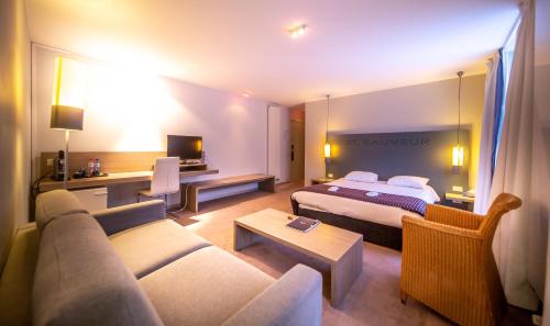 布兰肯贝赫Hotel Saint Sauveur by WP Hotels的酒店客房,配有床和沙发