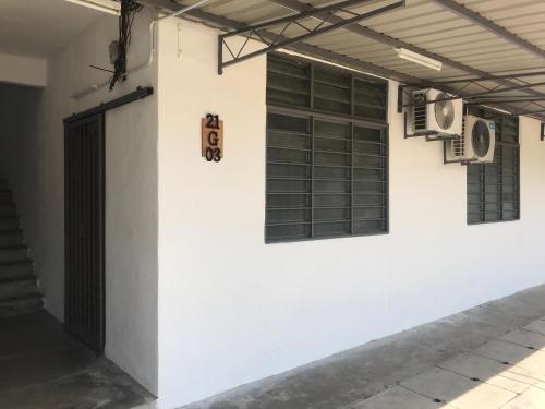 巴特沃思Abbie's Homestay Butterworth Penang的白色的墙壁,设有两扇窗户和一扇门