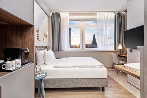 不莱梅不来梅H5+酒店的酒店客房设有床和窗户。