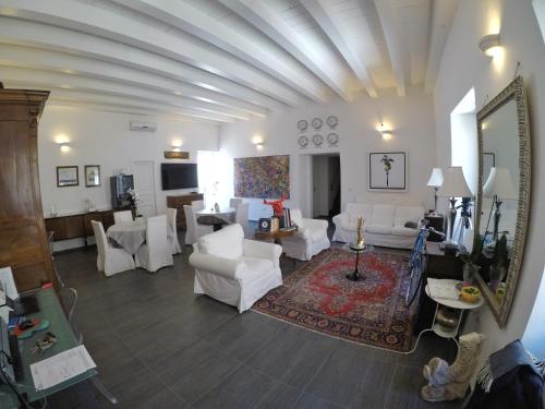 锡拉库扎雷吉纳尔公寓的客厅配有白色的沙发、桌子和镜子