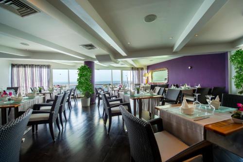 达喀尔Hotel Lagon 2的餐厅设有木桌、椅子和紫色墙壁
