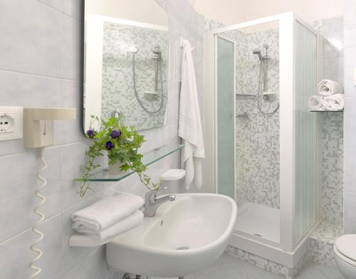里乔内小酒店的白色的浴室设有水槽和淋浴。