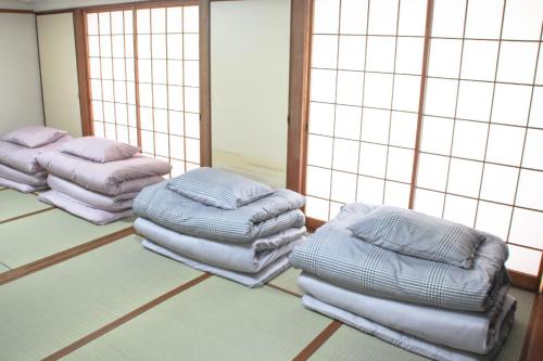 别府Beppu Kannawa Onsen HIROMIYA的一间房间,地板上设有三层枕头