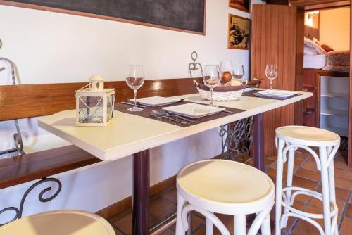 格罗韦A Escalinata Apartamento-Loft的厨房配有带酒杯和凳子的桌子