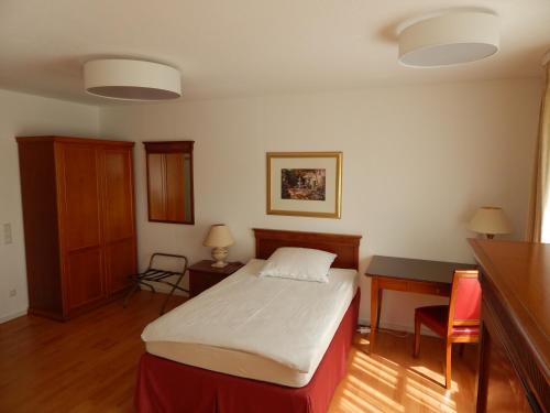 罗伊特林根FREE Apartment - Bei der Markthalle的一间卧室配有一张床、一张桌子和一张桌子