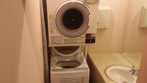 磐城Hotel Onahama Hills的盥洗盆旁浴室内的洗衣机