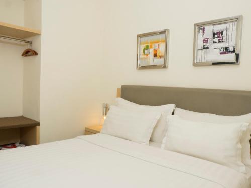 当格浪d'primahotel Airport 1的卧室配有白色的床铺和白色的枕头