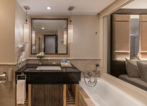 长滩岛和南恩花园度假酒店的一间带水槽、浴缸和镜子的浴室