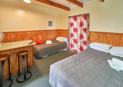 WoodvilleNew Central Hotel Woodville的酒店客房配有两张床和一张书桌