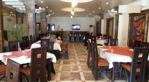 SargodhaSolo Hotel & Restaurant的餐厅内带桌椅的用餐室