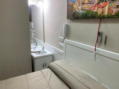 马拉加Apartments soho, Malaga center的一间带水槽和镜子的小浴室