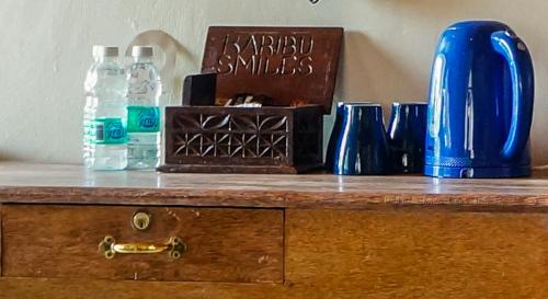 南威微笑海滩酒店 的配有瓶装水和蓝色花瓶的木制柜台